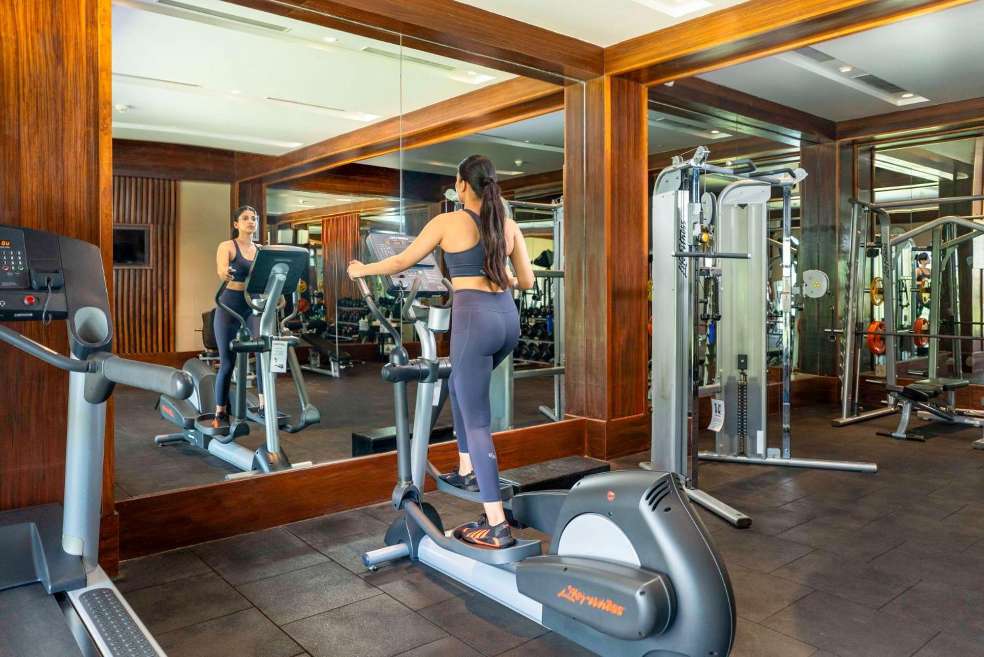 Radisson Blu Plaza Resort & Convention Centre Karjat Kültér fotó A woman on an elliptical trainer